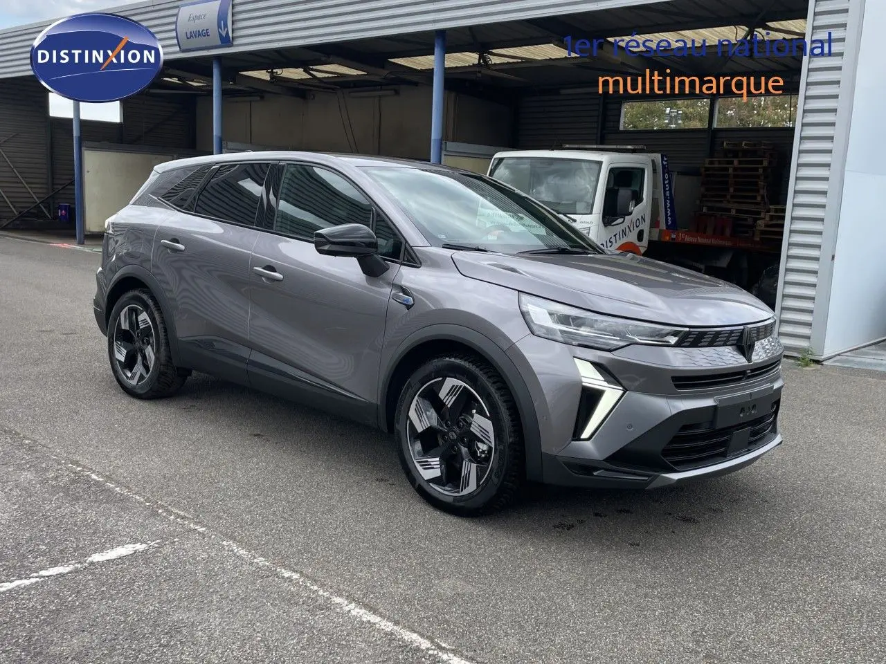Renault Symbioz gris cassiopée métal en 3/4 avant droit, avec jantes stylisées et feux LED distinctifs.