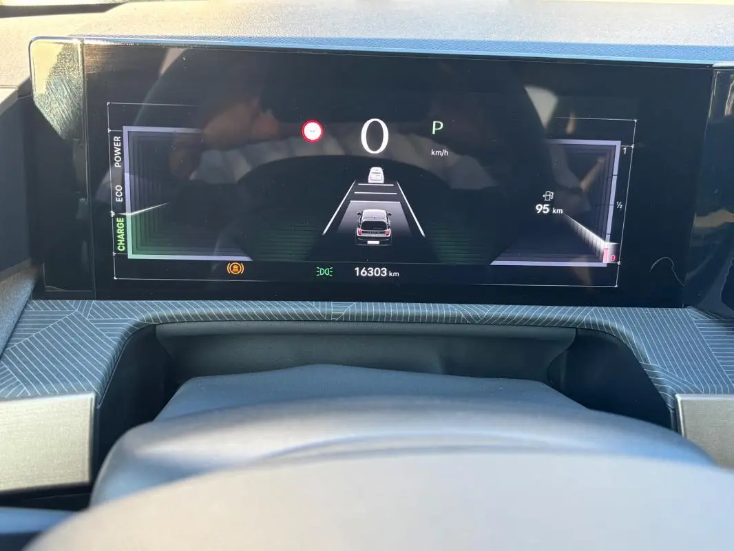 Vue intérieure du tableau de bord numérique de la Lancia Ypsilon gris, affichant la vitesse à zéro et l'autonomie restante.