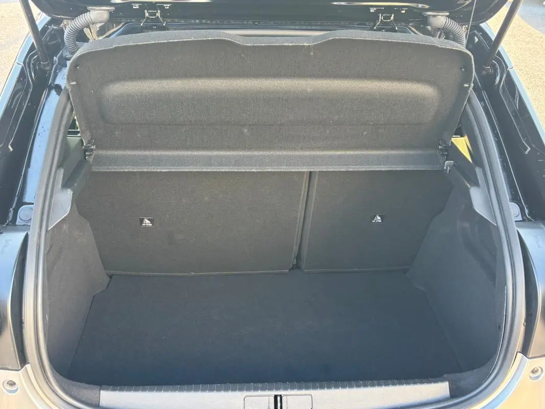 Coffre ouvert vu de dessus d'une Lancia Ypsilon gris 2025, montrant l'espace de rangement et la tablette arrière.