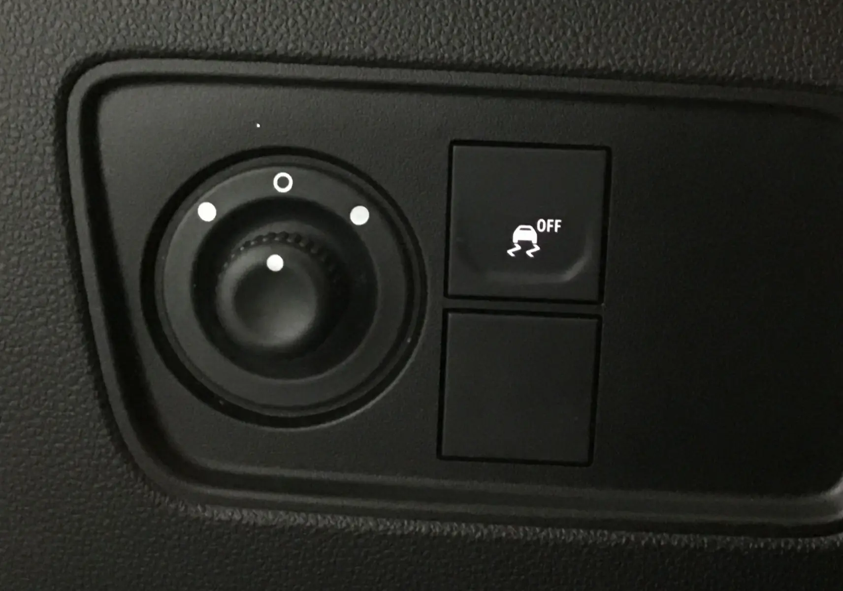 Gros plan sur les commandes de réglage des rétroviseurs et du contrôle de stabilité du Renault Express Van blanc 2023.