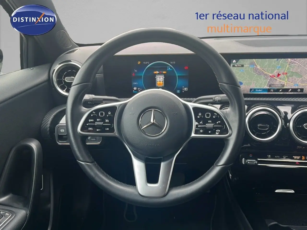 Vue intérieure centrée sur le volant cuir noir d'une Mercedes Classe A 180 Business Line avec écran digital et navigation.