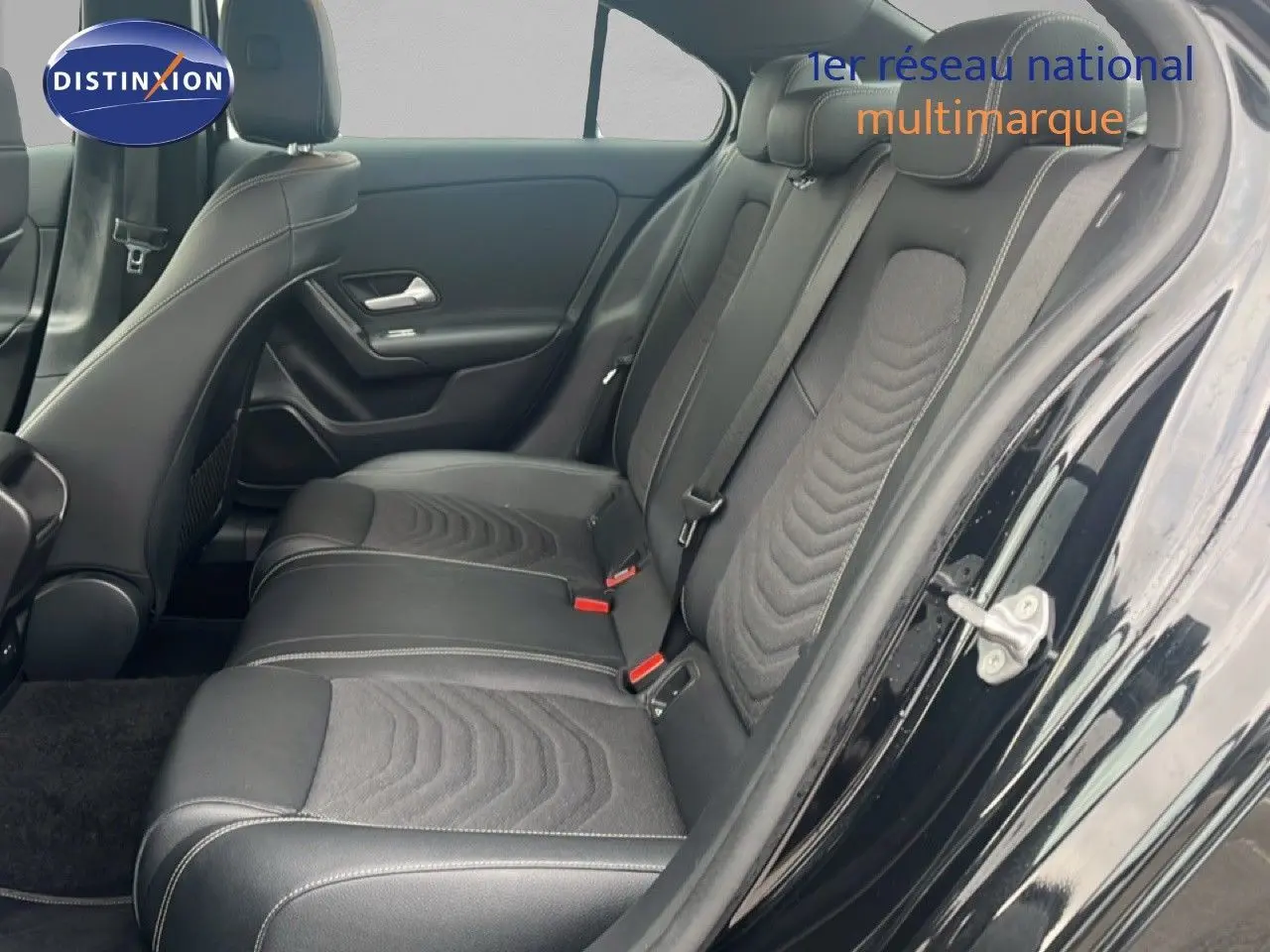 Vue côté droit de l'habitacle arrière d'une Mercedes Classe A 180 Business Line noire avec sièges cuir et tissu gris.
