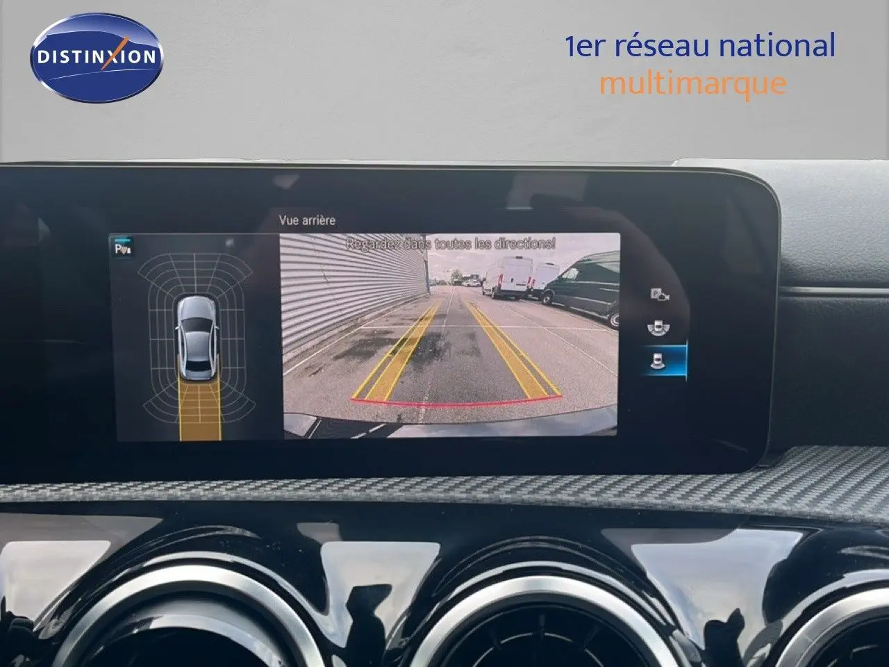 Écran multimédia affichant la caméra de recul et les capteurs de stationnement d'une Mercedes Classe A noire cosmos métal.