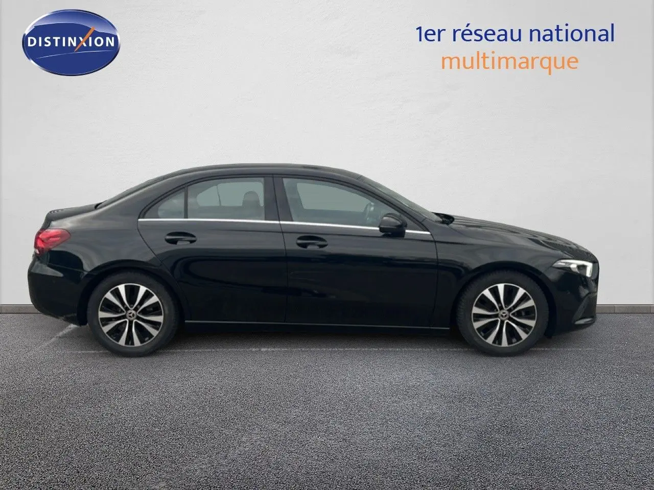 Profil côté gauche d'une Mercedes Classe A 180 Business Line noire Cosmos Metal, avec jantes alliage bicolores.