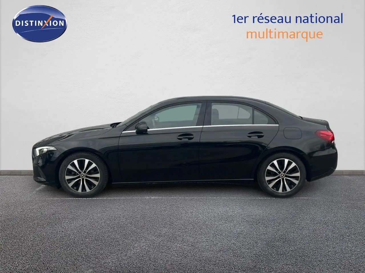 Vue de profil côté gauche d'une Mercedes Classe A 180 Business Line noire Cosmos métal avec jantes alliage bicolores.