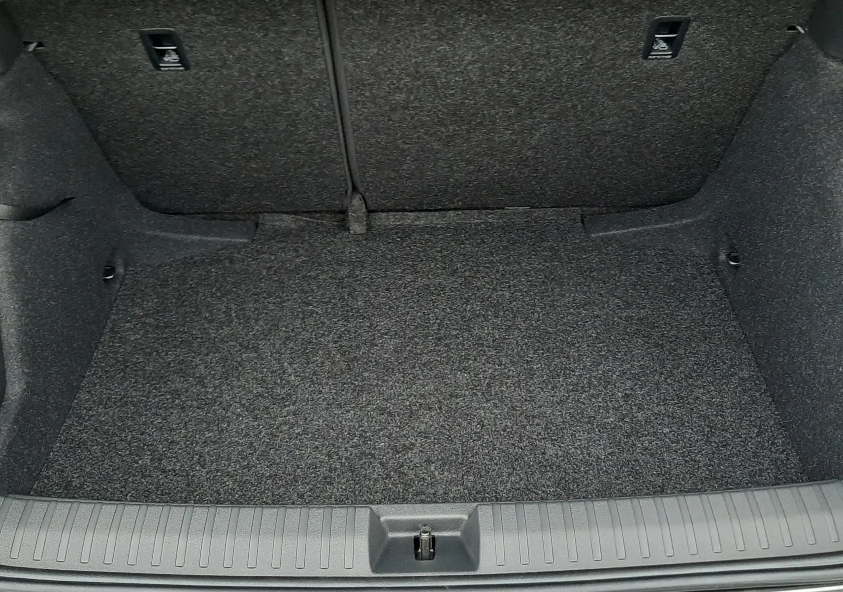 Coffre ouvert vu de face d'un Skoda Kamiq gris graphite métal 2025, intérieur en tissu gris foncé.