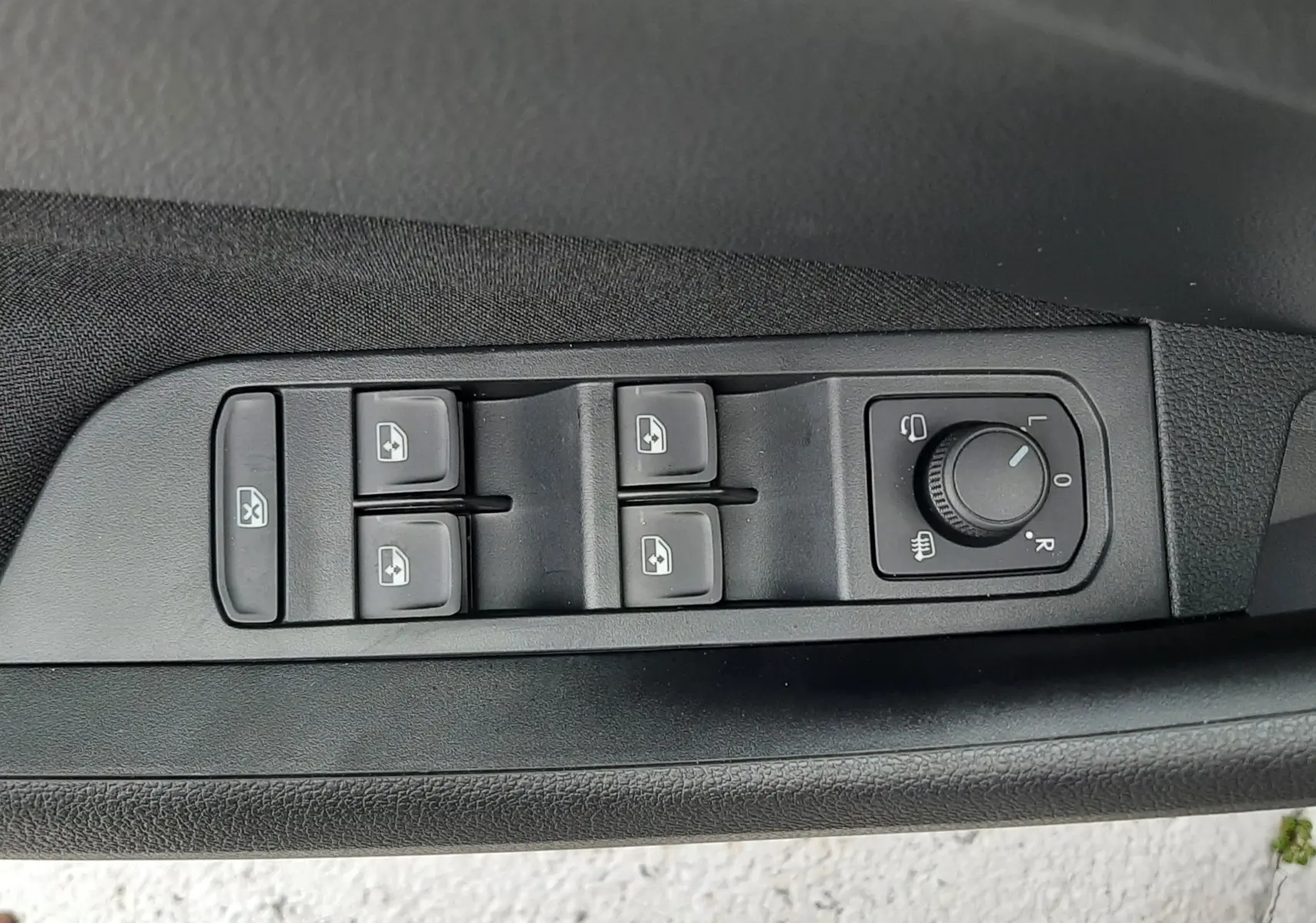 Panneau de commandes des vitres et réglage des rétroviseurs côté conducteur d'une Skoda Kamiq gris graphite 2025.