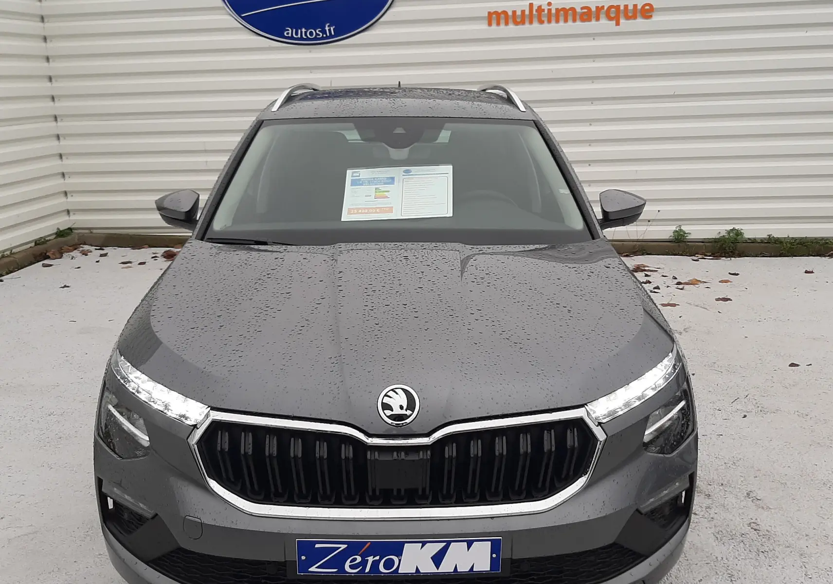 Vue frontale d'un Skoda Kamiq gris graphite métal 2025 avec calandre noire et phares LED allumés.