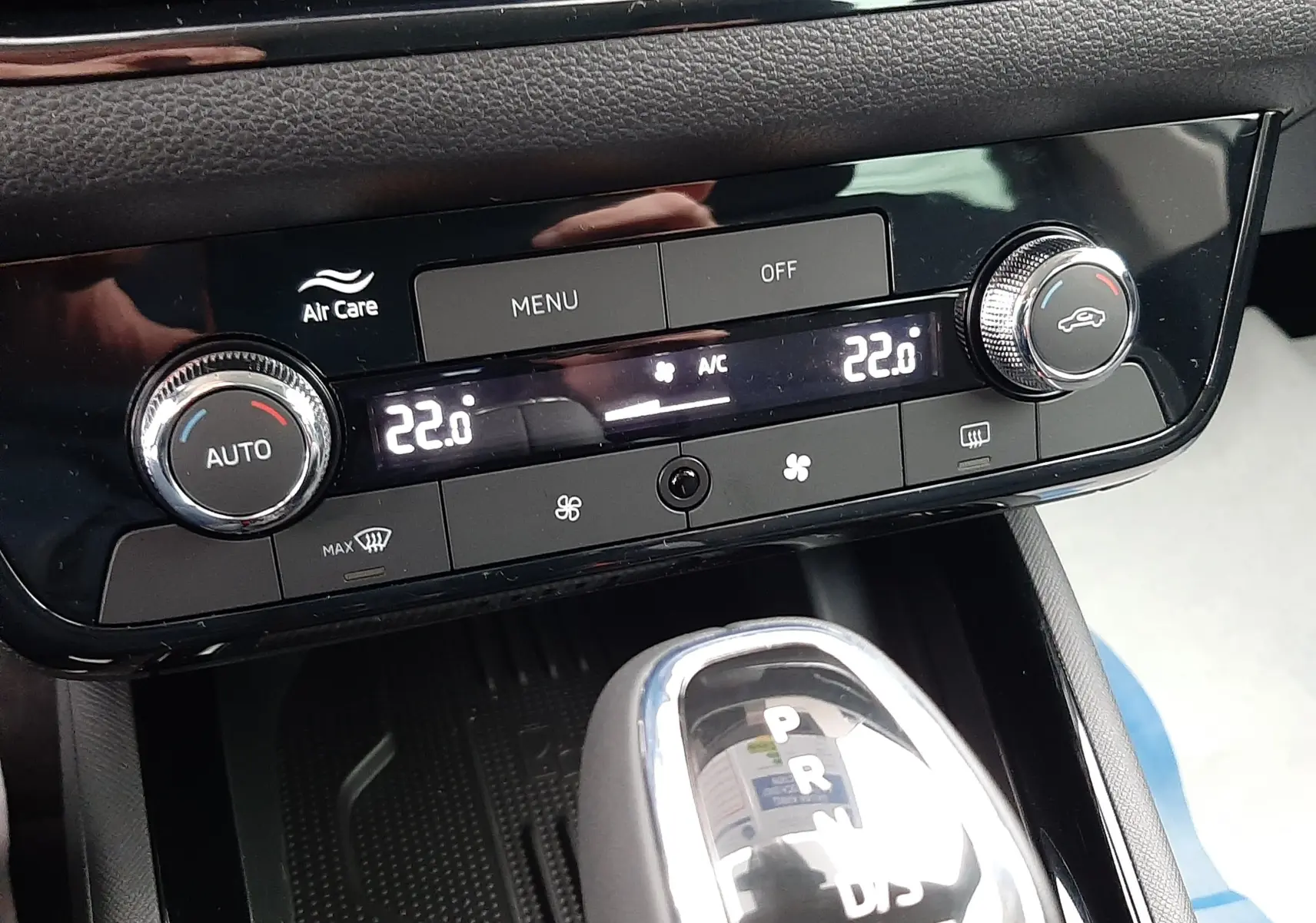 Vue rapprochée de la console centrale du Skoda Kamiq 2025 gris graphite, montrant la climatisation digitale et le levier de boîte auto.
