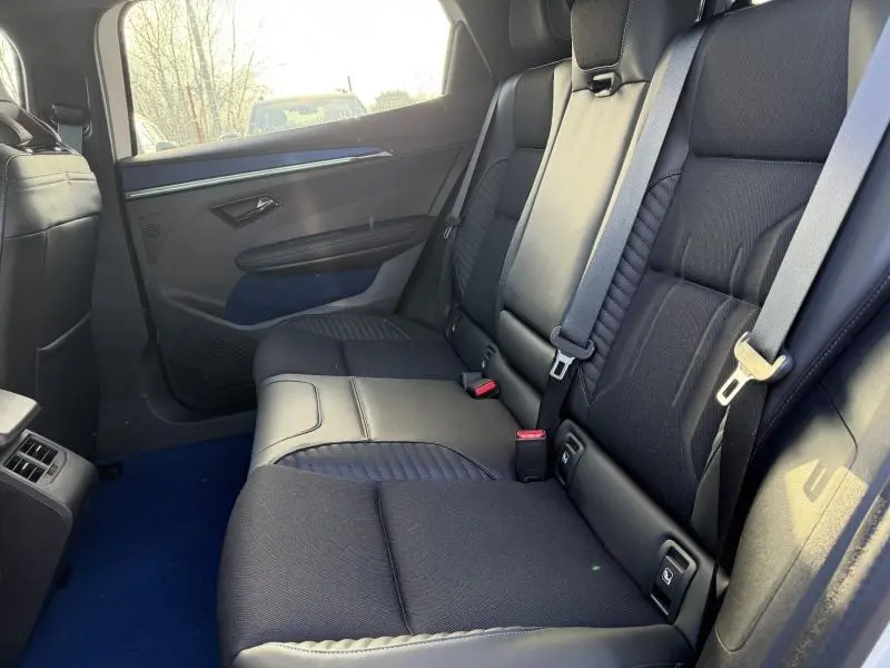 Vue intérieure côté gauche des sièges arrière noirs du Renault Scénic E-Tech Electric 2025 avec ceinture de sécurité et porte ouverte.