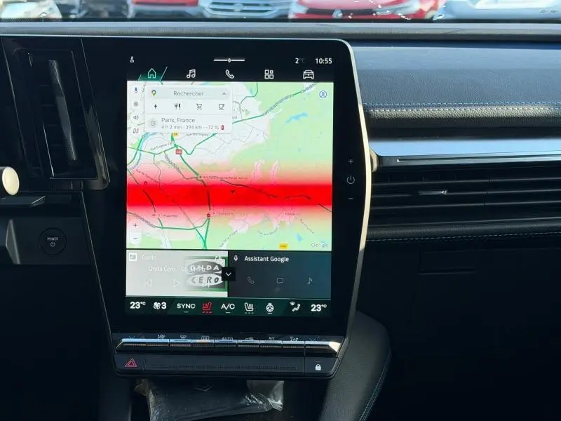 Intérieur du Renault Scénic E-Tech 2025 montrant l’écran tactile central avec navigation et commandes climatisation.