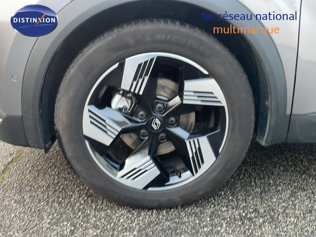 Gros plan sur la roue avant droite avec jante noire et grise du Renault Symbioz gris Casiopee Metal.