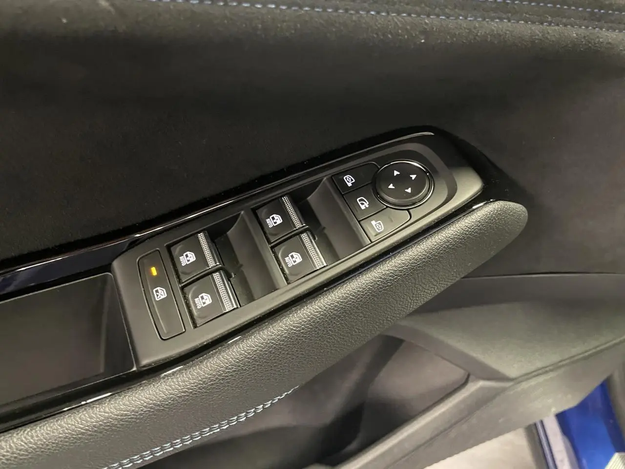 Détail de la commande des vitres électriques sur la porte côté gauche d’un Renault Austral 2024 Bleu Iron.