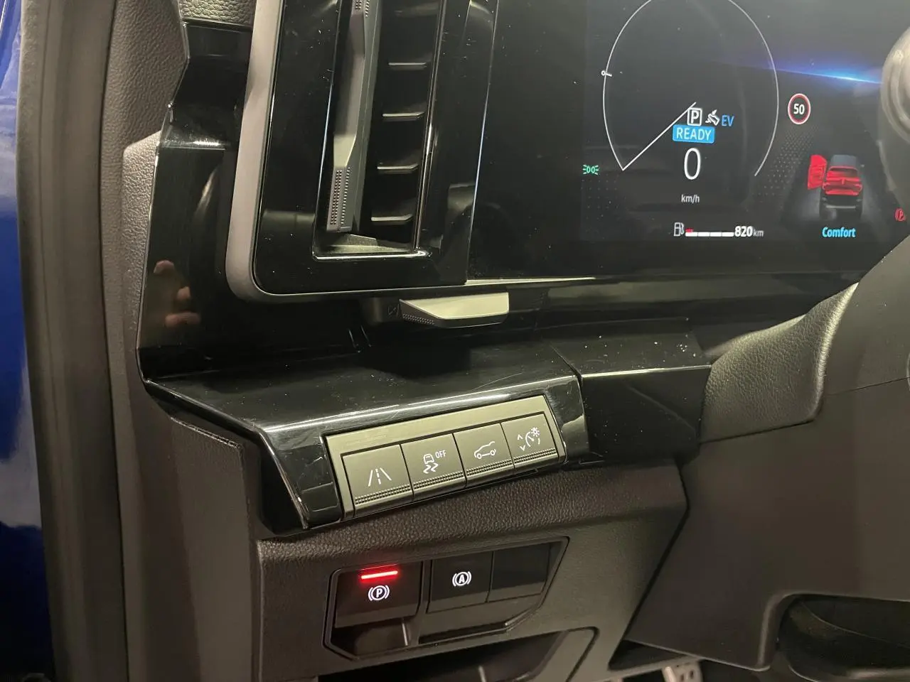 Vue intérieure côté gauche du tableau de bord du Renault Austral 2024 bleu, avec commandes d'aide à la conduite et écran digital.