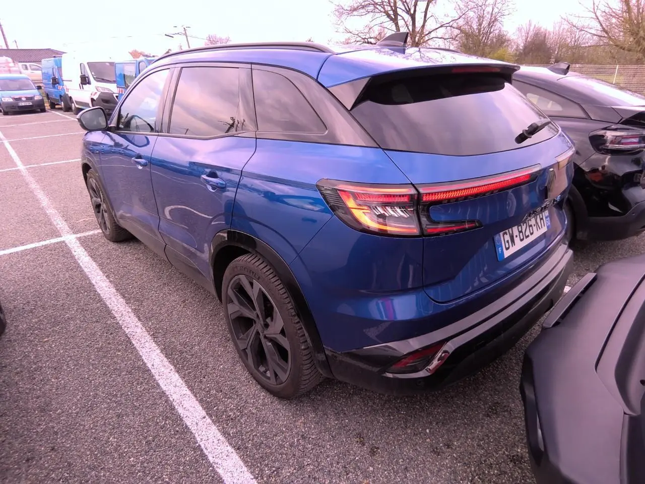Vue 3/4 arrière gauche du Renault Austral 2024 bleu Iron avec jantes noires et vitres teintées.