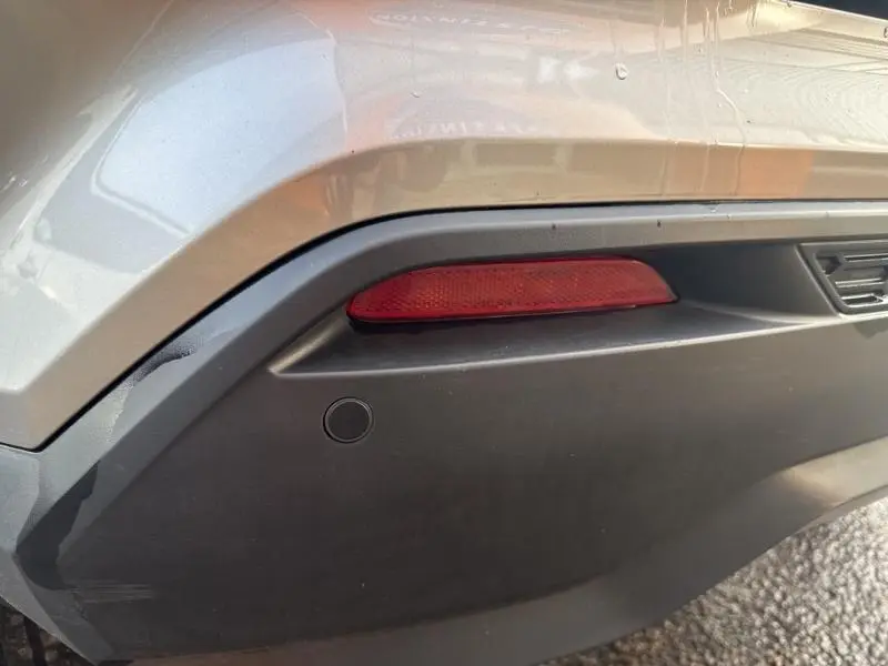 Gros plan sur le feu arrière et pare-chocs arrière gris perle métallisé du Nissan Juke 2022 côté droit.