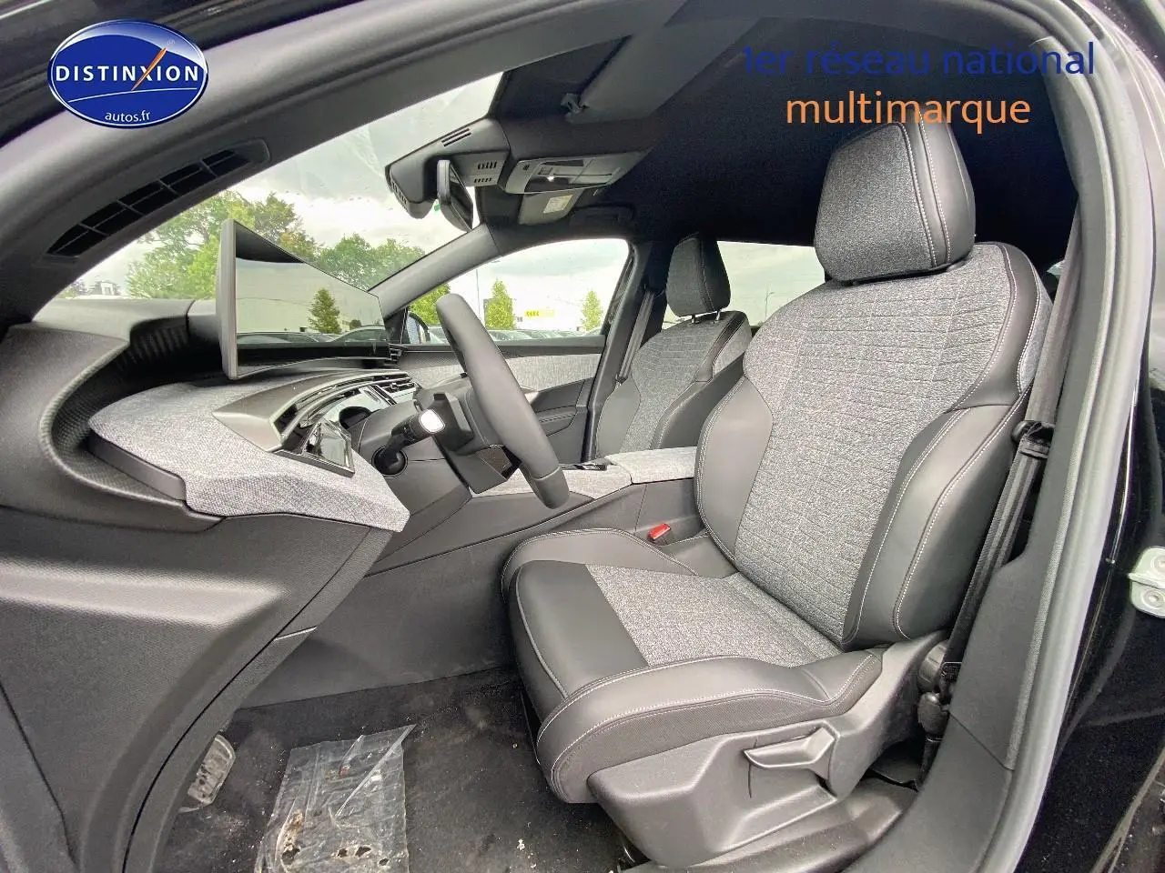 Vue intérieure côté conducteur du Peugeot 5008 Hybrid 145 allure e-dcs6 2025, sièges tissu gris et cuir noir.