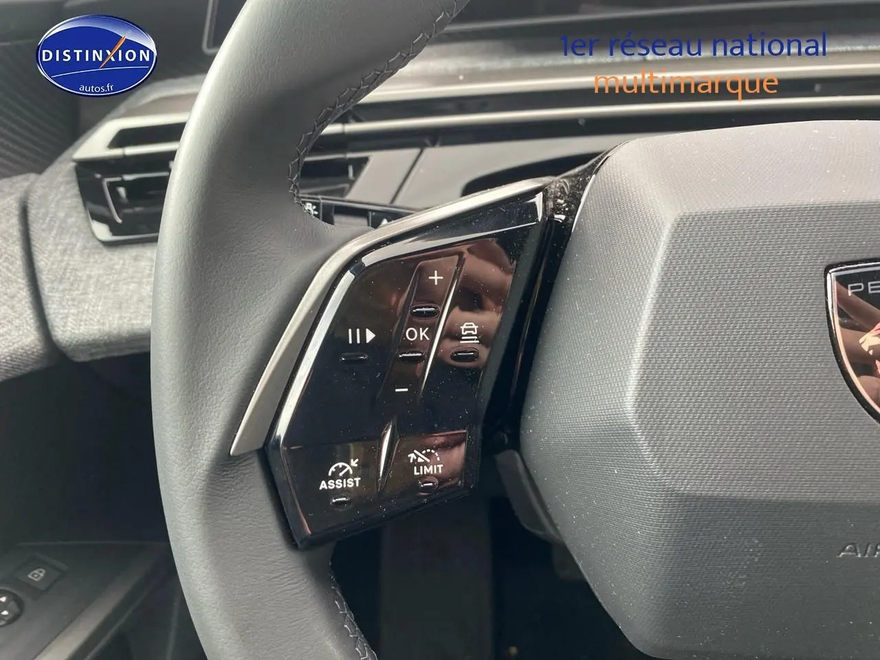 Gros plan sur le volant cuir noir du Peugeot 5008 Hybrid 145 allure 2025, avec commandes multifonctions visibles côté gauche.