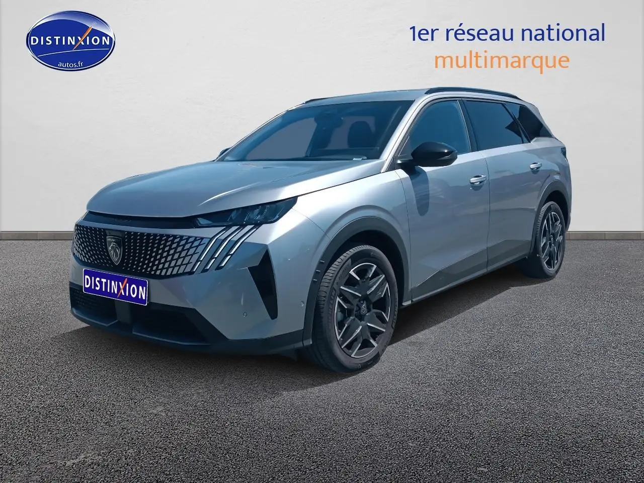 Peugeot 5008 gris artense en 3/4 avant droit, avec calandre distinctive et jantes alu modernes.