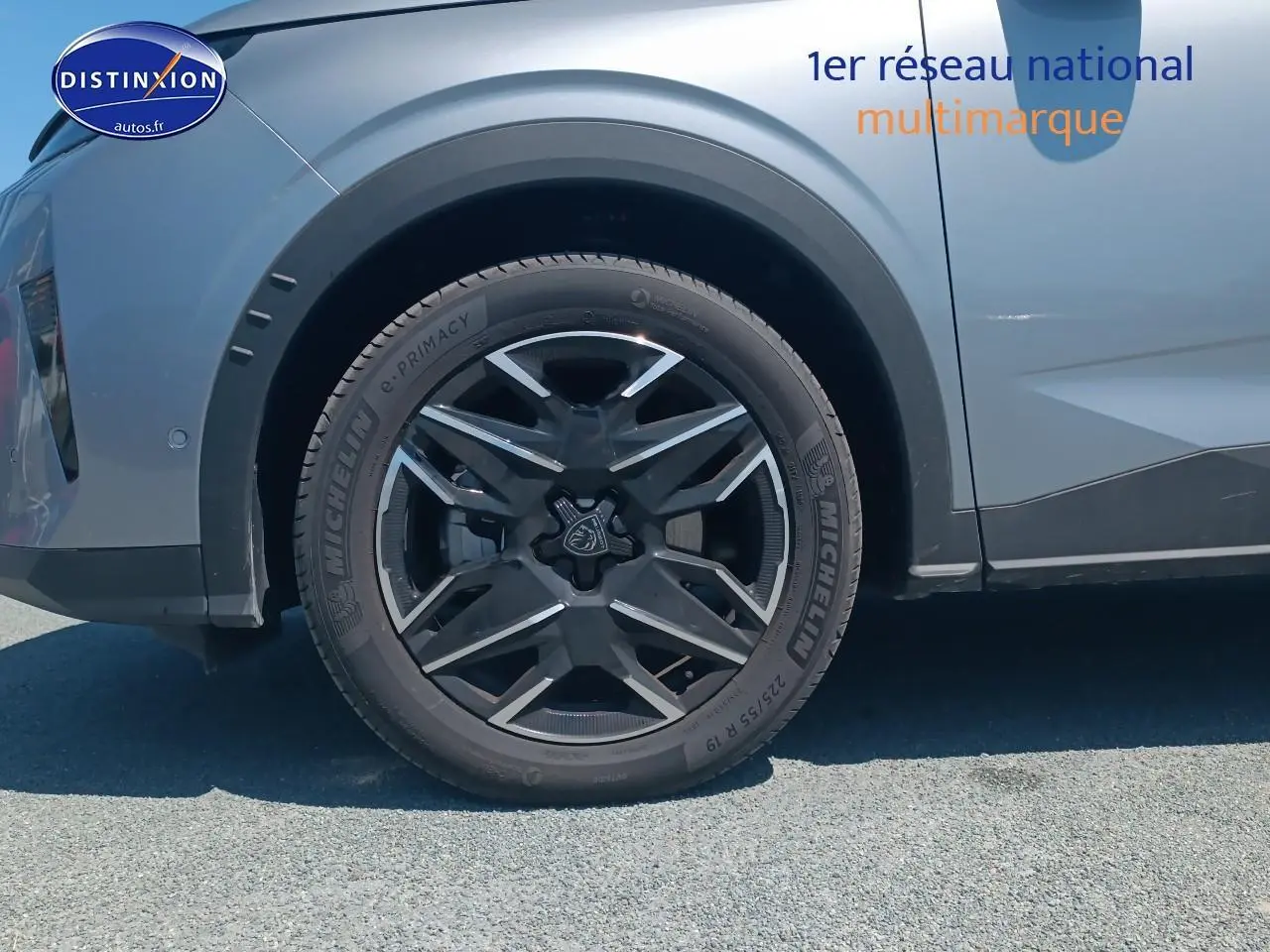 Gros plan sur la roue avant gauche du Peugeot 5008 gris artense, mettant en valeur la jante alu au design moderne.