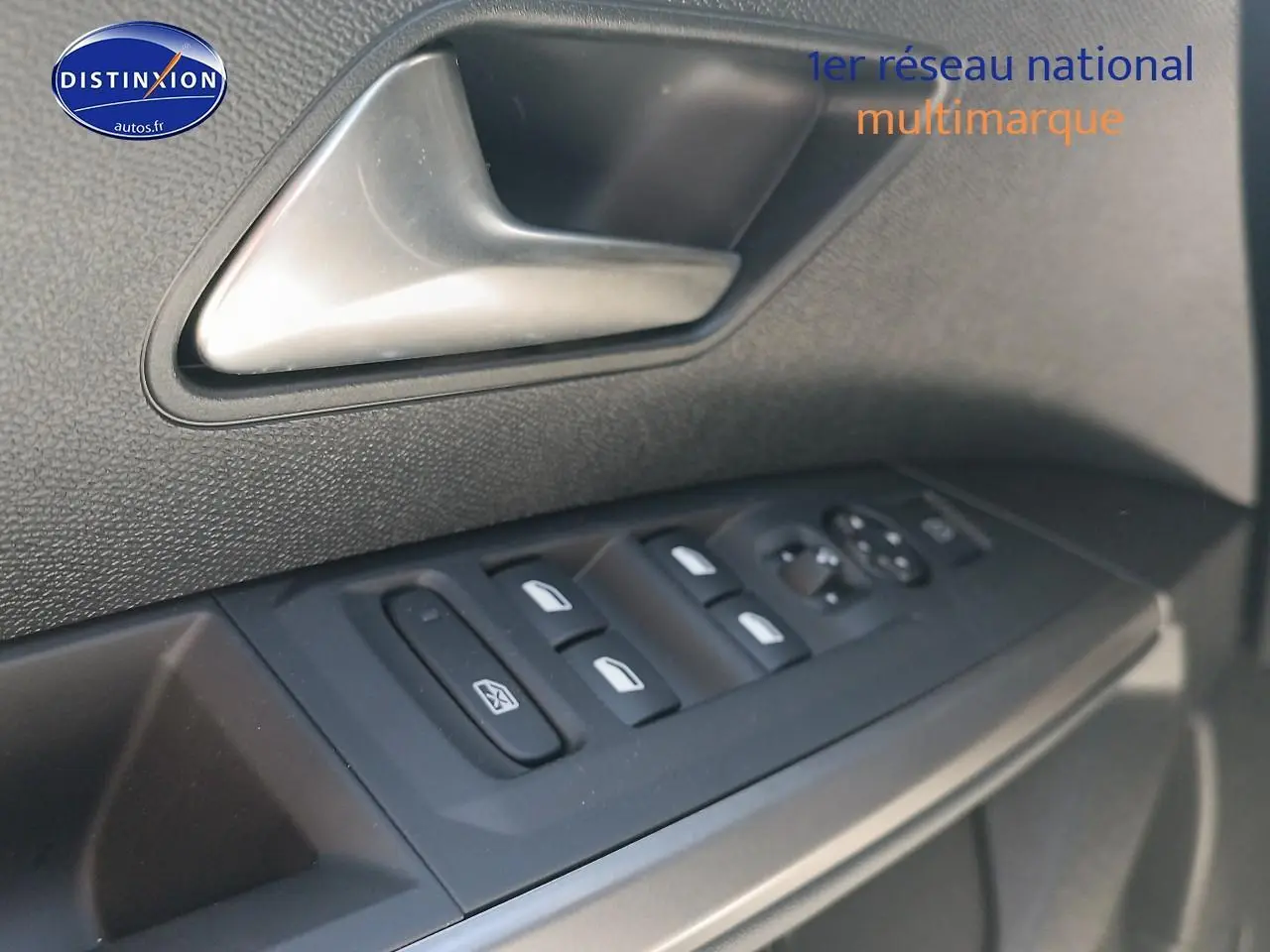 Gros plan sur la commande des vitres électriques côté conducteur du Peugeot 5008 gris Artense, avec poignée de porte intégrée.