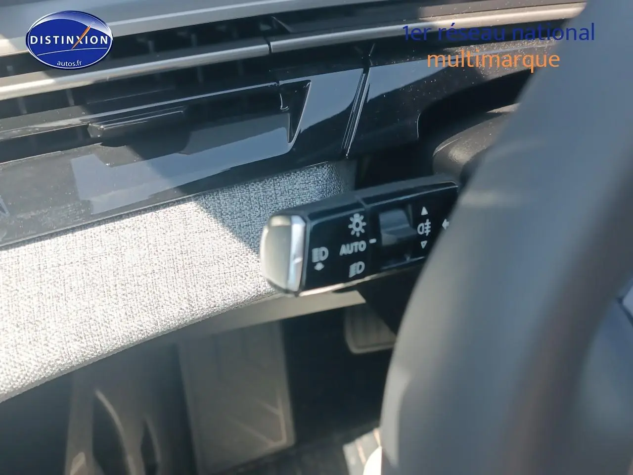 Détail intérieur du commutateur de phares sur le côté gauche du volant d’un Peugeot 5008 gris Artense 2025.