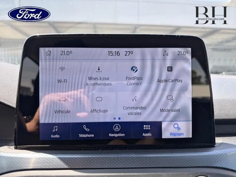Écran tactile central de la Ford Focus 1.0 Flexifuel 125ch Business affichant les options connectivité et réglages, intérieur noir.