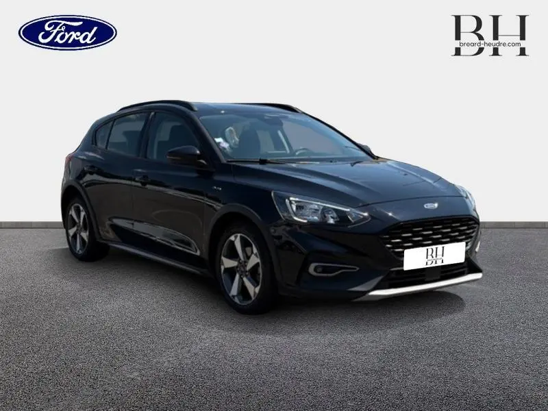 Ford Focus 1.0 Flexifuel noir Agate métallisé vue 3/4 avant droit avec jantes alu et calandre noire distinctive.