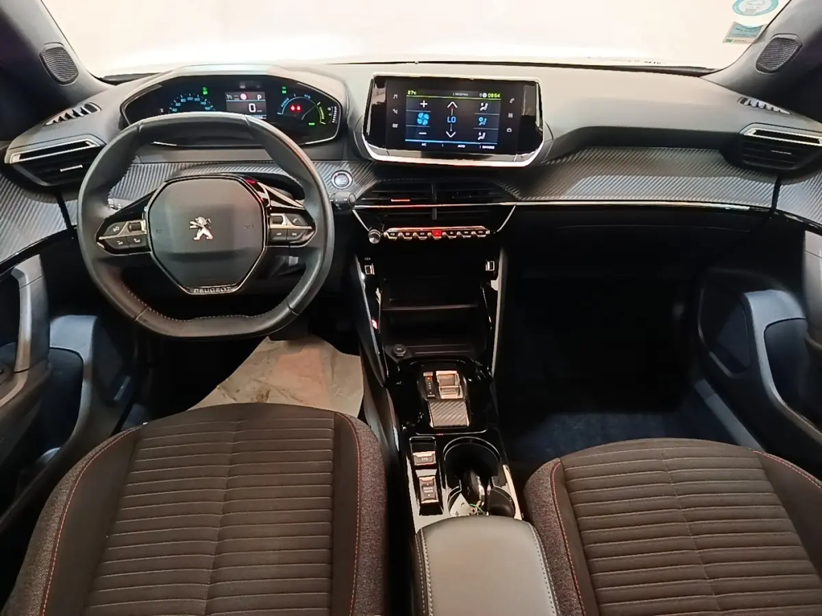 Vue intérieure avant du Peugeot E-2008 électrique 2023, volant cuir multifonctions et écran tactile central.