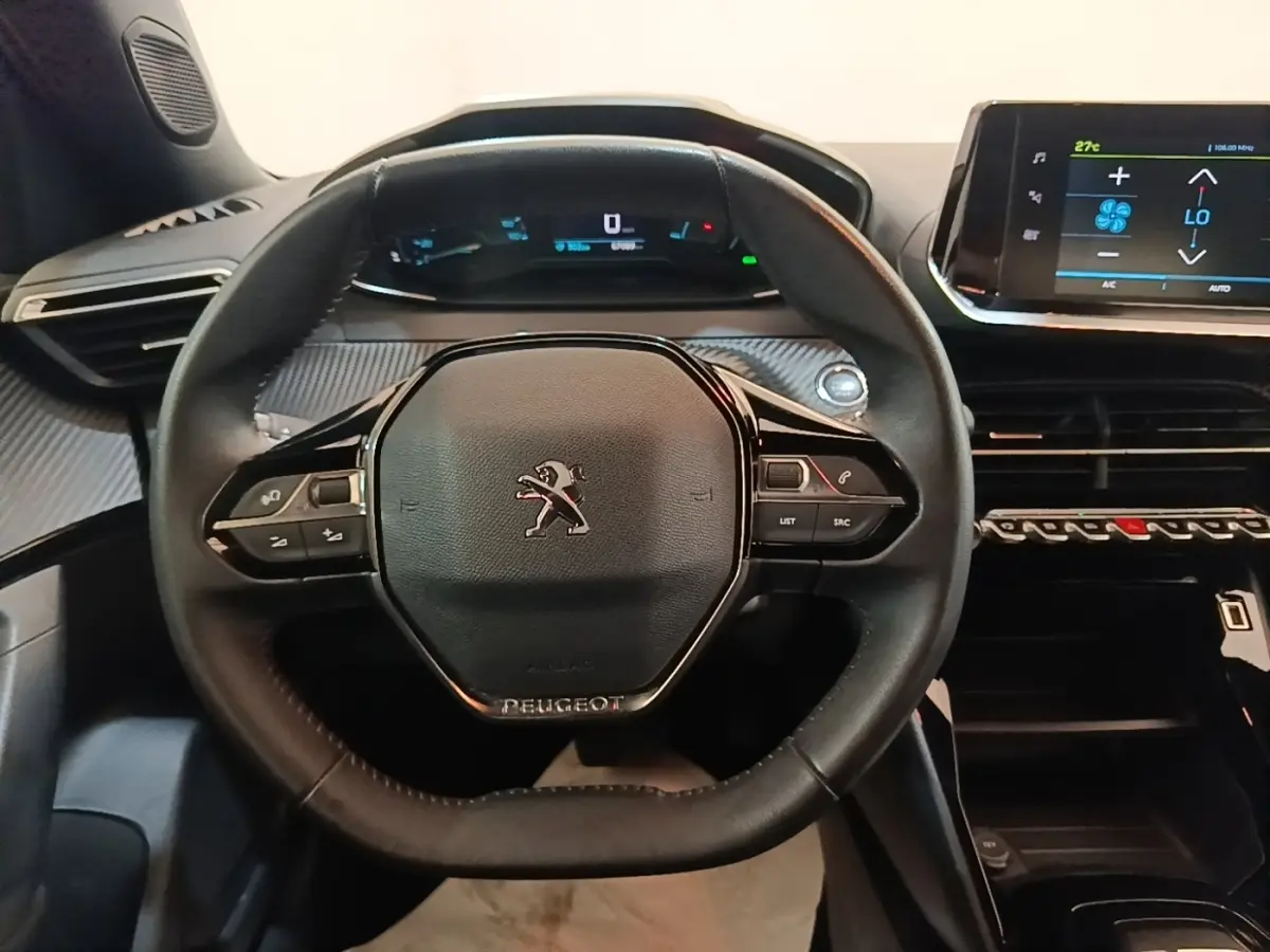 Vue rapprochée du volant cuir multifonctions noir du Peugeot E-2008 électrique Active Pack 2023 avec tableau de bord digital.