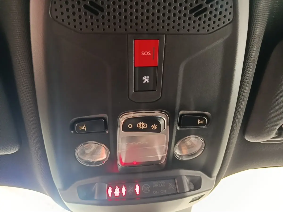 Plafonnier intérieur avec bouton SOS rouge et commandes d’éclairage dans un Peugeot E-2008 électrique gris clair 2023.