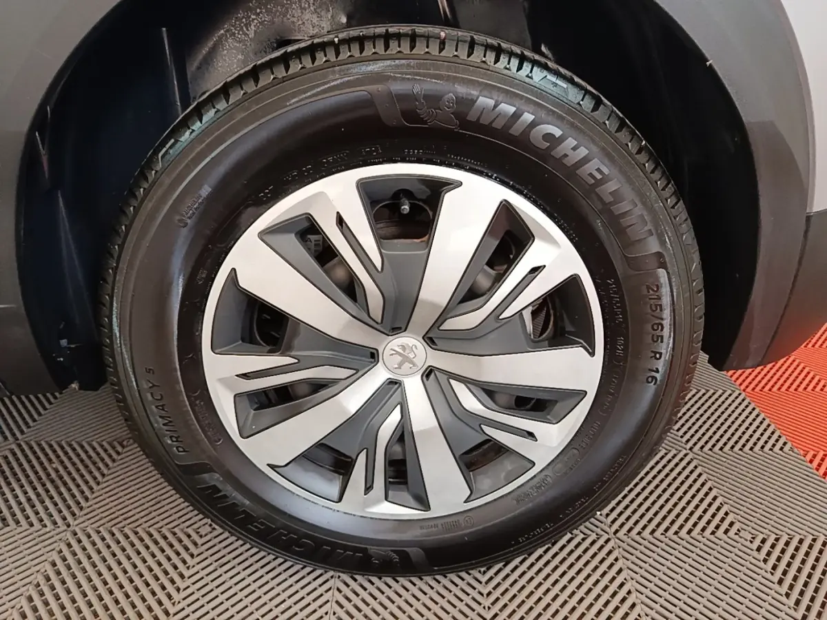 Gros plan sur la roue avant droite du Peugeot E-2008 électrique gris clair avec jante spécifique et pneu Michelin.