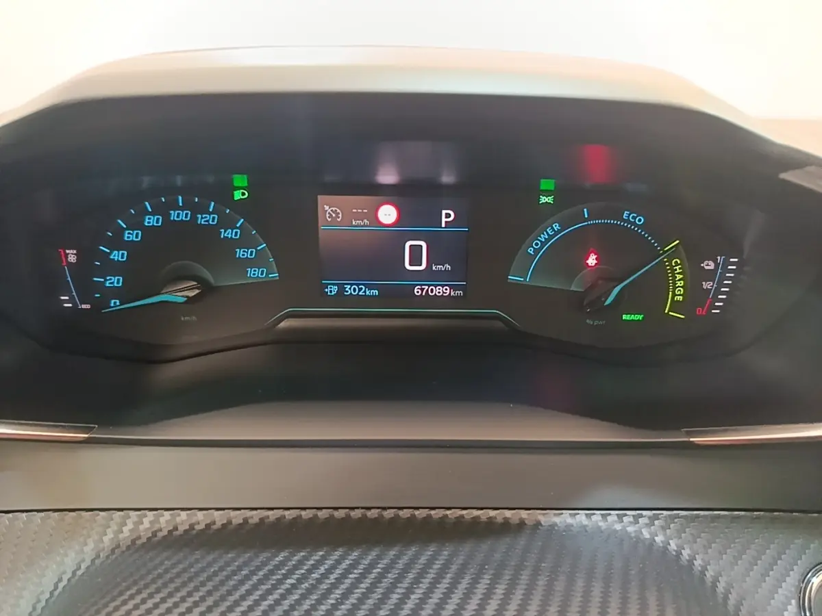 Vue rapprochée du tableau de bord numérique du Peugeot E-2008 électrique, affichant vitesse, autonomie et indicateurs de charge.