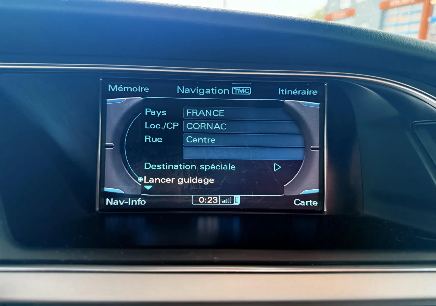 Écran de navigation central affichant un itinéraire en cours dans un Audi A5 gris, vue intérieure du tableau de bord.