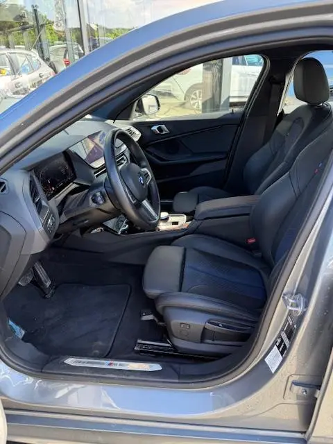 Vue intérieure côté conducteur de la BMW Série 1 118d gris foncé, avec sièges sport et tableau de bord numérique.