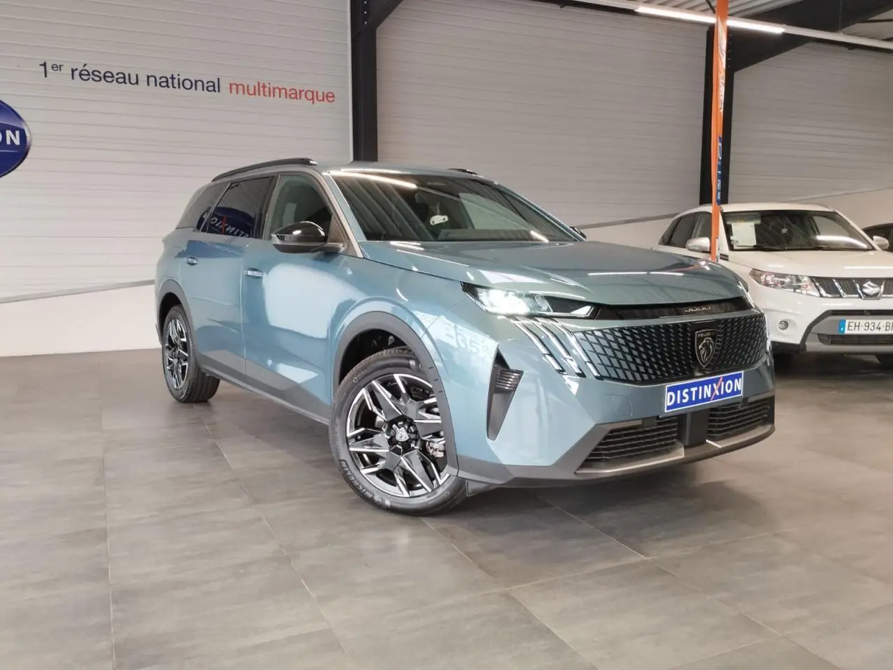 Peugeot 5008 bleu Ingaro en 3/4 avant droit, avec jantes alliage 19'' et calandre noire laquée.