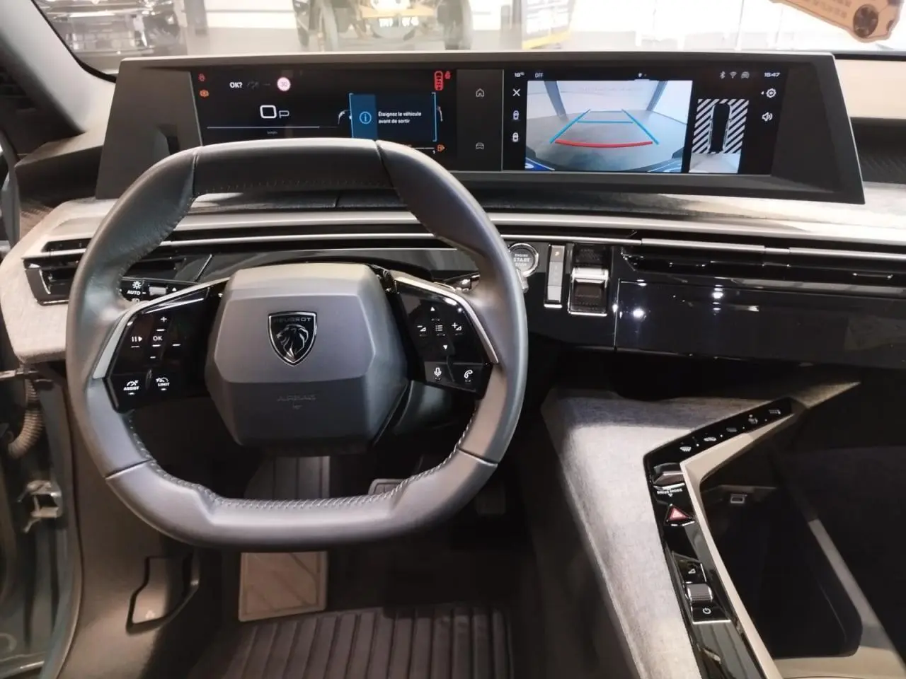 Vue intérieure du tableau de bord du Peugeot 5008 2025, volant compact cuir et double écran HD panoramique.