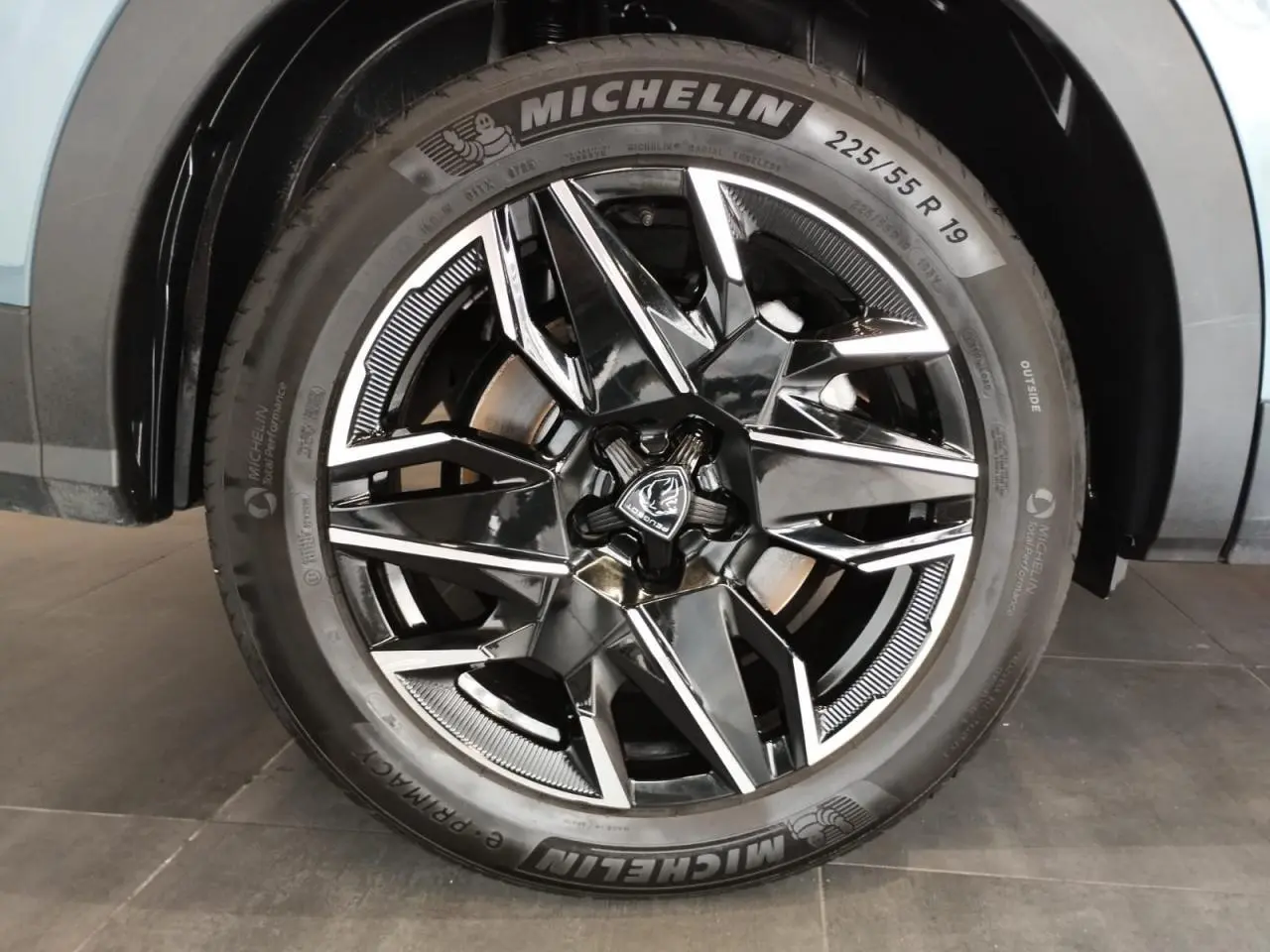 Gros plan sur la jante alliage 19'' diamantée noire et brillante du Peugeot 5008 Bleu Ingaro, avec pneu Michelin visible.