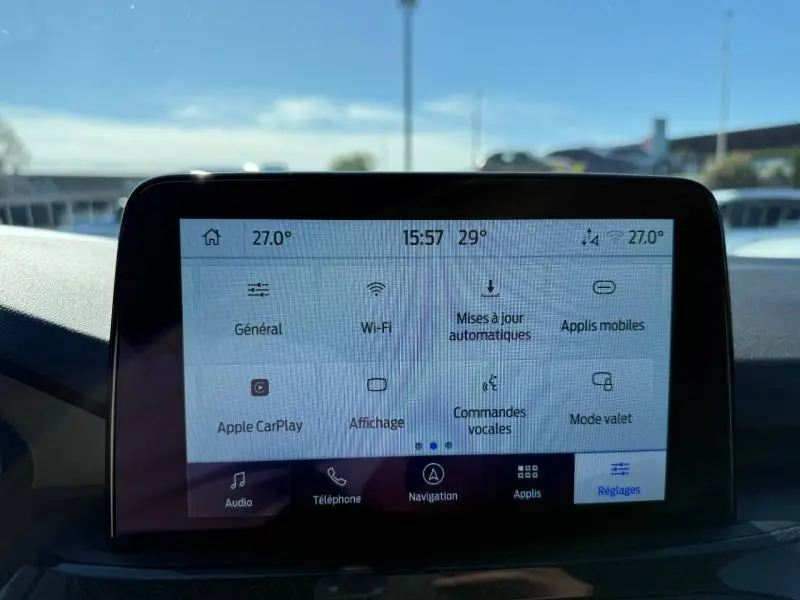 Écran tactile central du Ford Kuga 2024 affichant les réglages de connectivité et de climatisation, vue intérieure frontale.