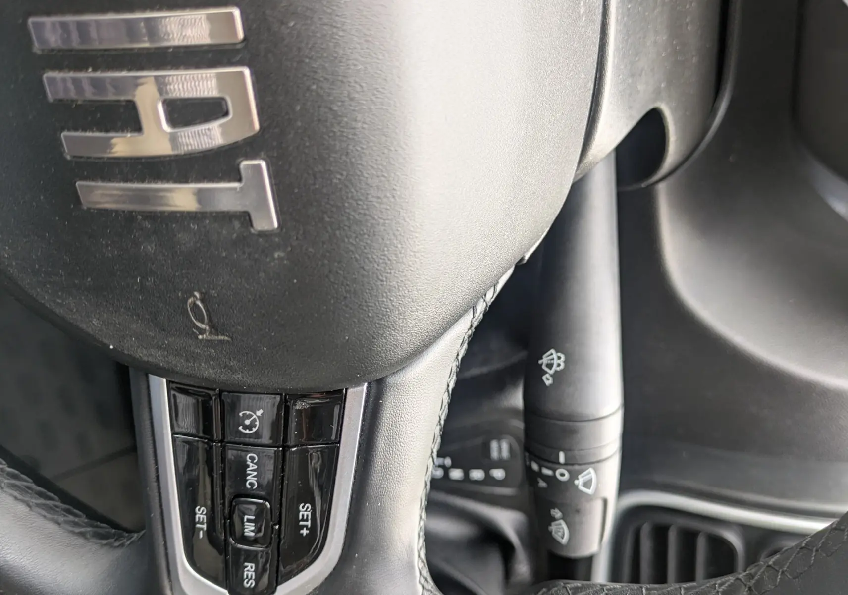 Gros plan sur le volant noir du Fiat Ducato Fourgon 2025 avec commandes intégrées et logo FIAT visible.