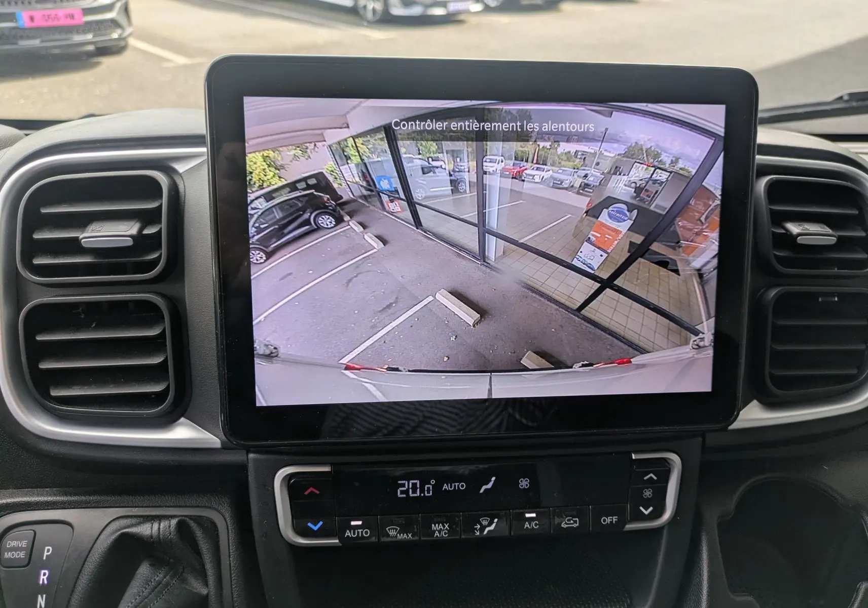 Vue intérieure du tableau de bord du Fiat Ducato Fourgon 2025 avec écran de caméra de recul et commandes climatisation.