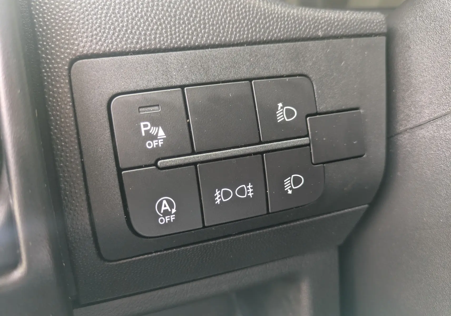 Gros plan sur les boutons de commande noirs du tableau de bord du Fiat Ducato Fourgon 2025, avec symboles blancs.