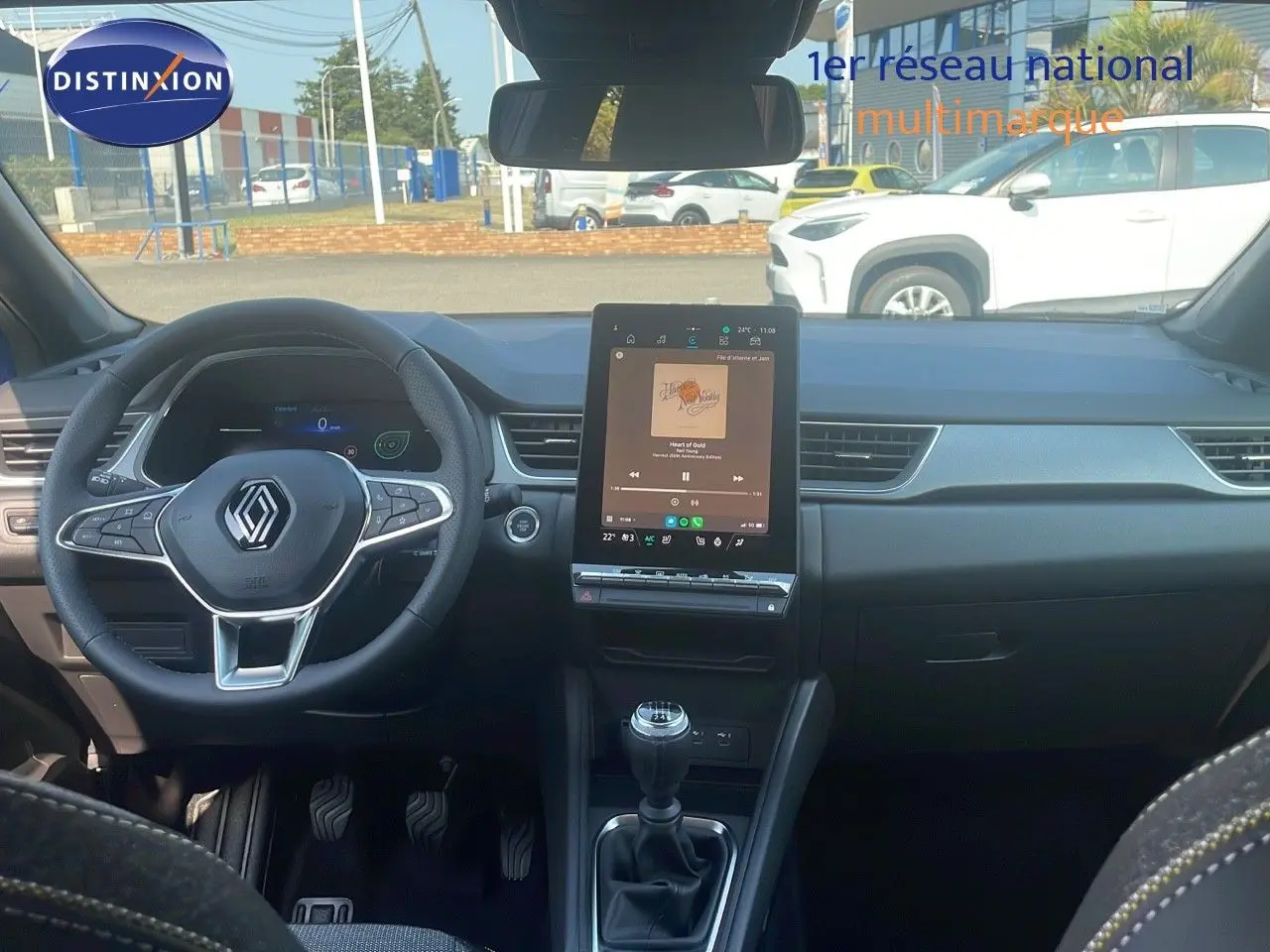 Intérieur de Renault Captur 2025 avec tableau de bord moderne, écran tactile vertical et volant multifonction noir.