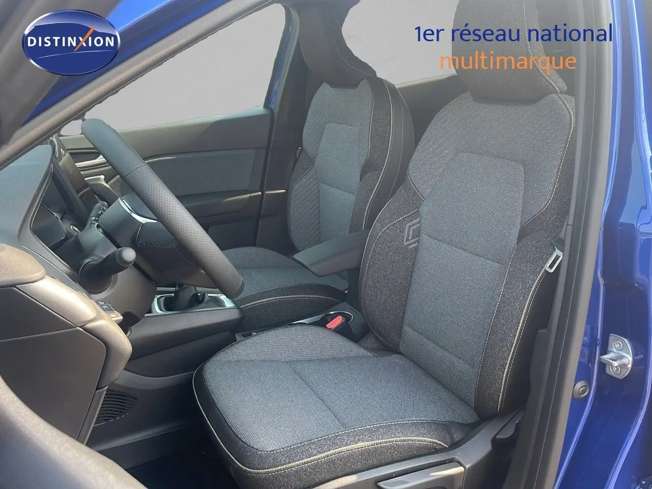 Vue intérieure côté conducteur du Renault Captur bleu Iron Metal 2025, sièges tissu gris avec surpiqûres claires.
