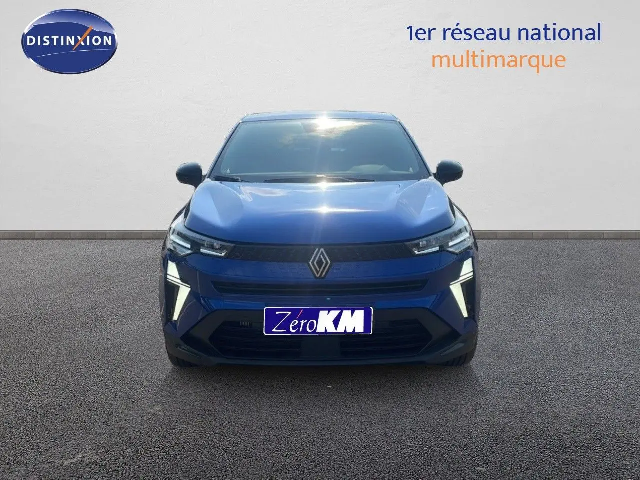 Vue frontale d'un Renault Captur bleu Iron Metal 2025 avec feux LED allumés et logo Renault bien visible.