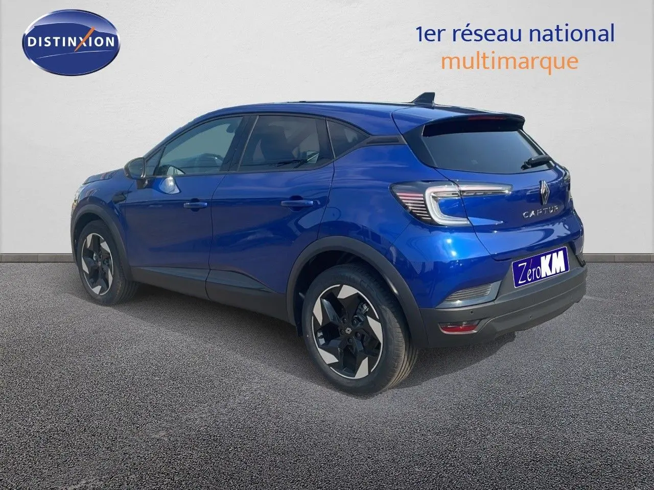 Renault Captur bleu Iron Metal en 3/4 arrière droit, SUV compact avec jantes bi-ton et feux LED distinctifs.