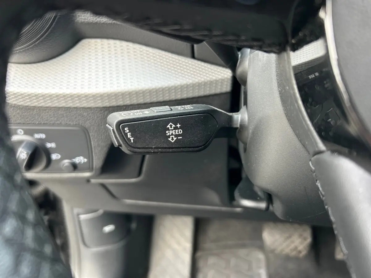 Le levier de régulateur de vitesse noir sur le côté gauche du volant d’un Audi Q2 35 TFSI 2023.