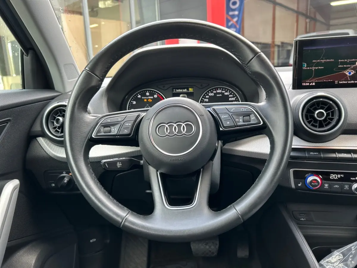Volant cuir noir Audi Q2 35 TFSI 2023 vu de face, avec tableau de bord et écran tactile de navigation visible