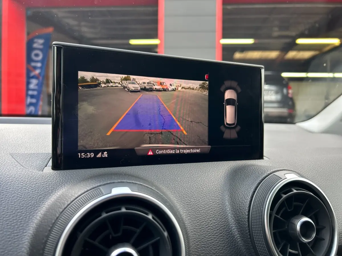 Écran central de l'Audi Q2 noir 2023 montrant la caméra de recul avec guidage de trajectoire en parking.