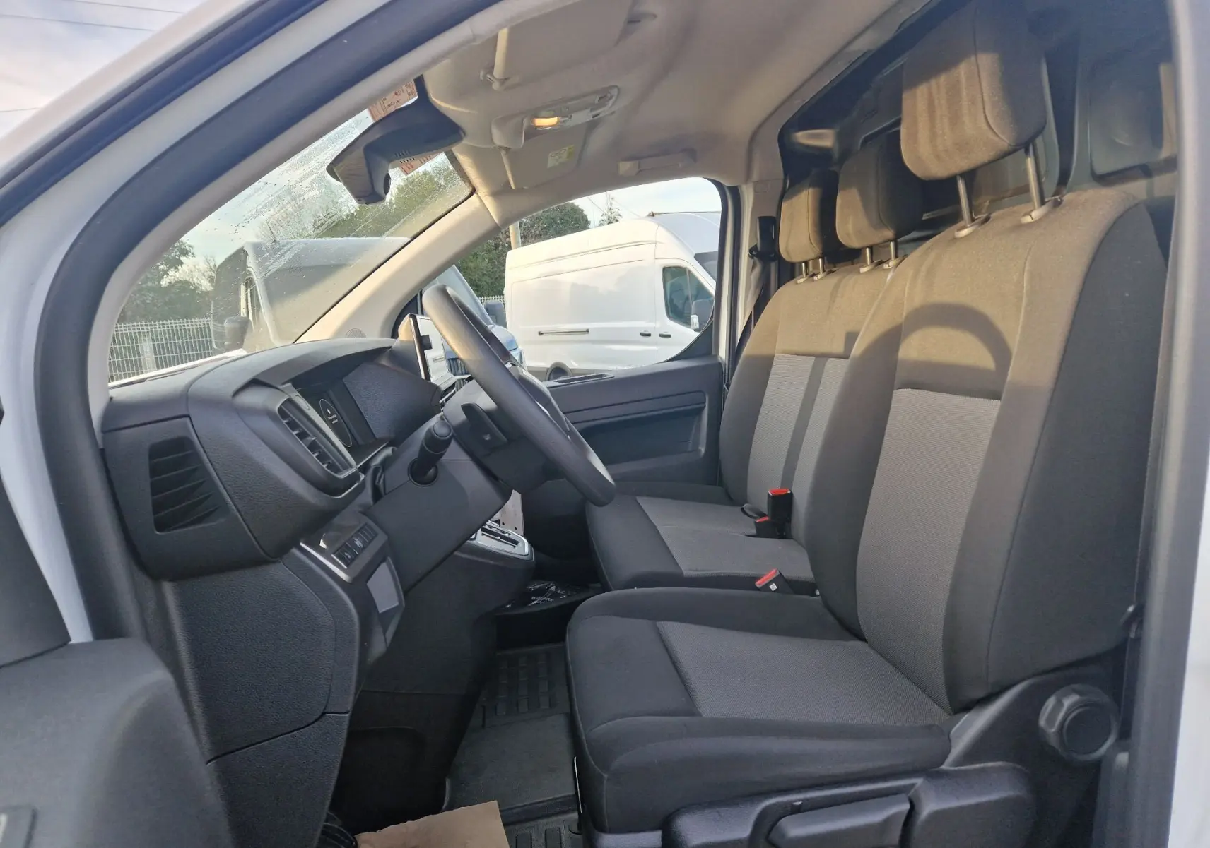 Intérieur du FIAT Scudo Fourgon blanc 2024, vue côté conducteur montrant les sièges avant et le tableau de bord.